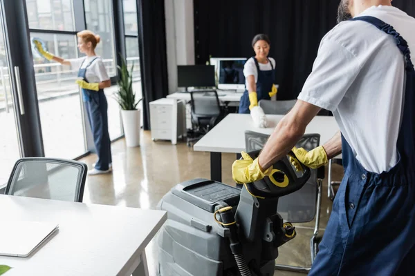 Hombre Con Fregadora Pisos Cerca Mujeres Multiétnicas Lavando Ventanas Muebles — Foto de Stock