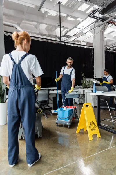 Mann Mit Wischmopp Und Wagen Mit Putzutensilien Der Nähe Multiethnischer — Stockfoto