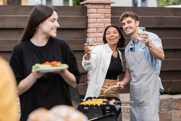 Smiling Interracial Friends Holding Wine Food Grill Backyard — Stock Photo, Image