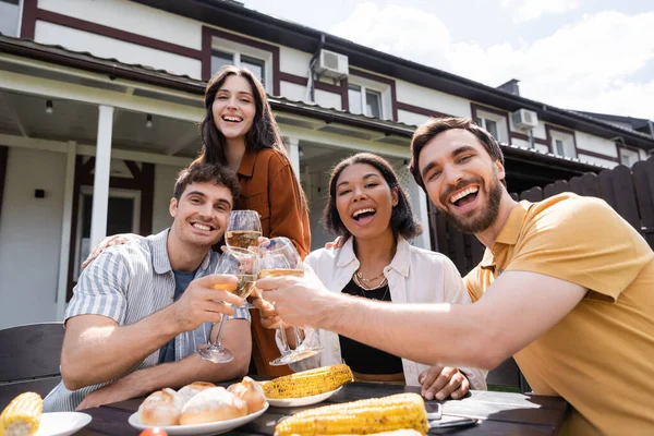 Positivo Interracial Amigos Tostadas Con Vino Mirando Cámara Cerca Comida — Foto de Stock