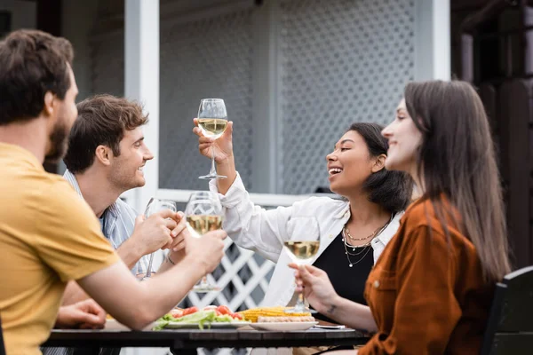 幸せな二人種間の女性は裏庭でBbqパーティー中にガラスの近くの友人と乾杯 — ストック写真