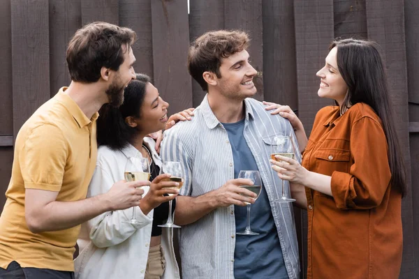 Vrolijk Interraciale Vrienden Houden Bril Met Wijn Terwijl Glimlachen Buurt — Stockfoto