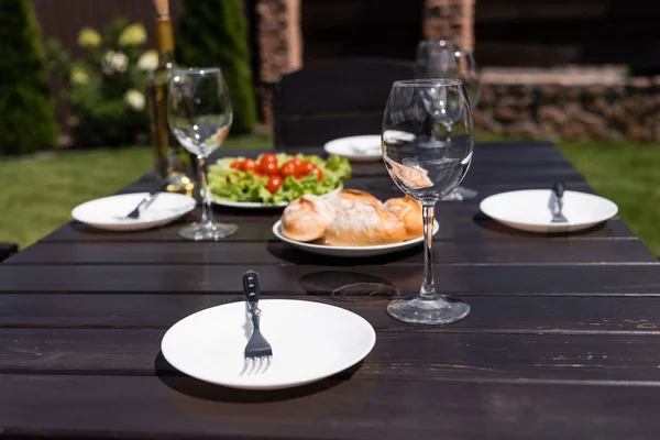 皿の近くのきれいなワイングラスとテーブルの上の前菜を務め — ストック写真