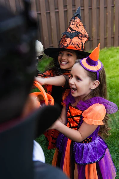 Usmívající Dívky Halloween Kostýmy Drží Kbelík Bonbóny Dvorku — Stock fotografie