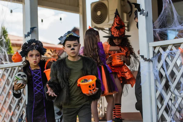 Multiethnic Kids Halloween Costumes Holding Buckets Candies Grimacing Outdoors — Stock Photo, Image