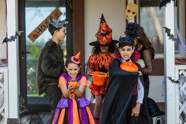 Multietnické Děti Halloween Kostýmy Držení Dýně Blízkosti Přátel Dvorku — Stock fotografie