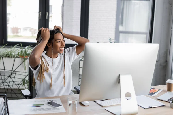 Empresária Americana Africana Alegre Tocando Cabelo Perto Dispositivos Papéis Escritório — Fotografia de Stock