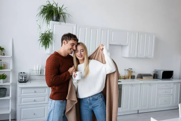 Caring Man Holding Blanket Pleased Girlfriend Sweater Cup Tea — Stock Photo, Image