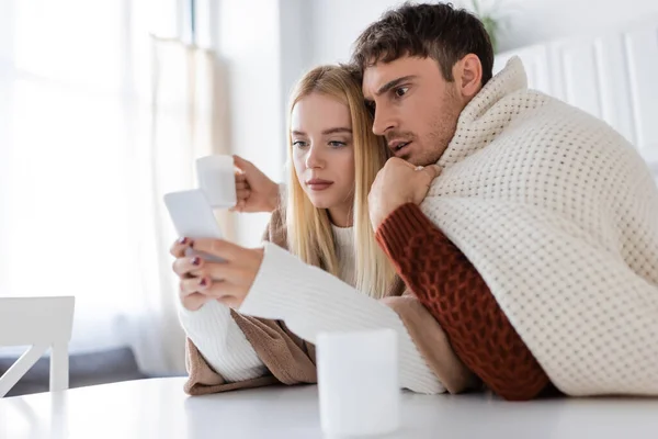 Mujer Joven Rubia Usando Smartphone Cerca Novio Taza Mesa — Foto de Stock