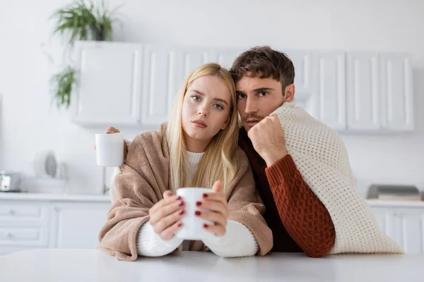 Young Couple Covered Blanket Holding Cups Tea Home — Stock Photo, Image