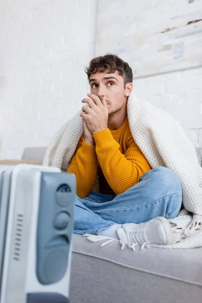 Young Man Covered Blanket Sitting Sofa Blurred Heater Winter — Stock Photo, Image