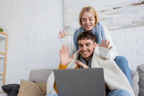 Cheerful Young Couple Scarfs Waving Hands Video Call Laptop — Stock Photo, Image