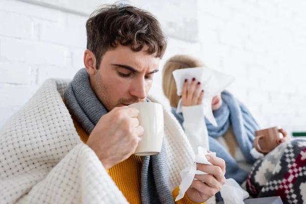 Sick Man Drinking Tea Holding Tissue Blonde Girlfriend Living Room — Stock Photo, Image