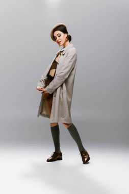 # Bereli zarif genç bir kadın # # Gri renkte poz veren şık bir yağmurluk #