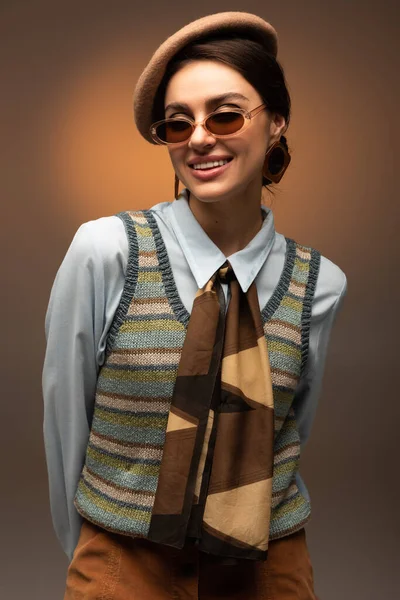 Uśmiechnięta Młoda Kobieta Berecie Stylowe Okulary Przeciwsłoneczne Patrzące Kamerę Brązowym — Zdjęcie stockowe