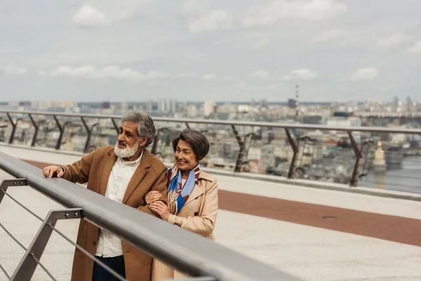 穿着外套的快乐老人和站在桥头堡旁的快乐女人 — 图库照片