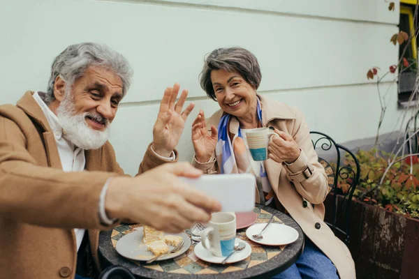 Feliz Pareja Ancianos Teniendo Videollamadas Saludando Las Manos Durante Desayuno — Foto de Stock