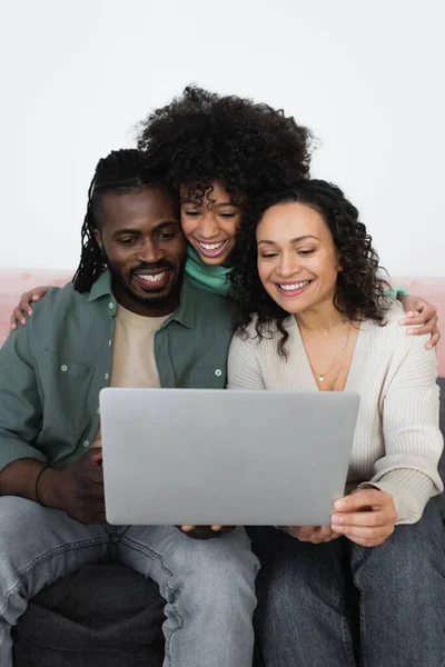 快乐的非洲裔美国父母和在客厅里用笔记本电脑看电影的未成年少女 — 图库照片