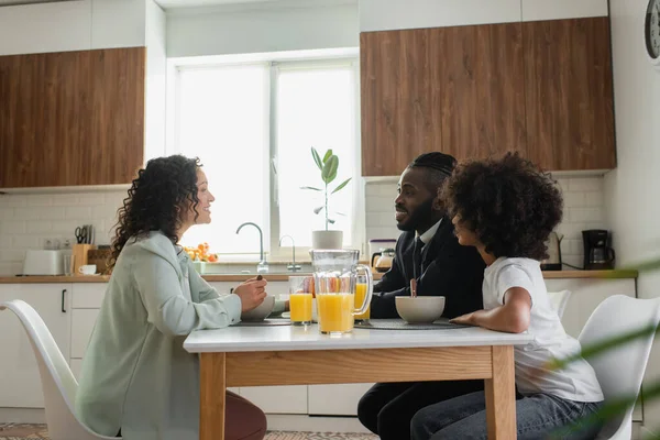 キッチンで朝食を食べながら笑顔を見せるアフリカ系アメリカ人の家族 — ストック写真