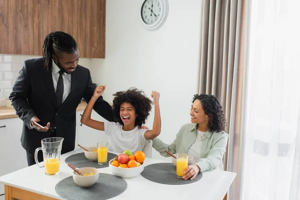 幸せなアフリカ系アメリカ人の両親は朝食中に興奮した娘を見て — ストック写真