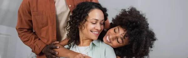 Glad Afrikansk Amerikansk Flicka Kramas Lycklig Mor Nära Far Fana — Stockfoto