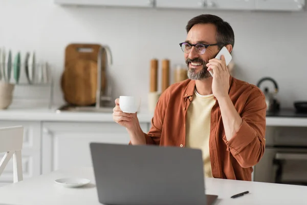 Vrolijk Man Bril Houden Koffie Kopje Praten Mobiele Telefoon Buurt — Stockfoto