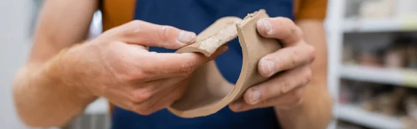 陶芸教室バナーの間のエプロンモデリング粘土の作品で人間のクロップドビュー — ストック写真