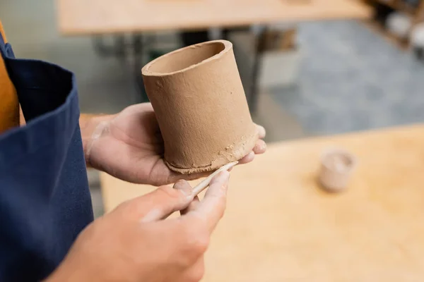 木の形をした粘土のカップを成形する男の部分的な見解 — ストック写真