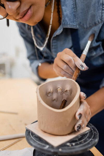 Cropped view of african american craftswoman working on clay product in pottery workshop 