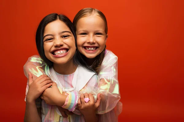 Overjoyed Preteen Girls Hugging Smiling Camera Isolated Orange — Stock Photo, Image