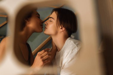 Genç ırklar arası sanatçıların yan görüntüsü bulanık ön planda kapalı gözlerle yüz yüze