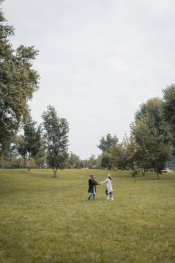 Parkta vakit geçirirken el ele tutuşan mutlu bir adam ve memnun bir kadın. 