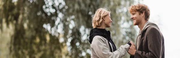 Redhead Man Blonde Woman Coat Smiling While Holding Hands Outdoors — Stock Photo, Image