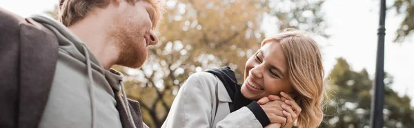 Joyful Blonde Woman Holding Hand Redhead Boyfriend While Smiling Park — Stock Photo, Image