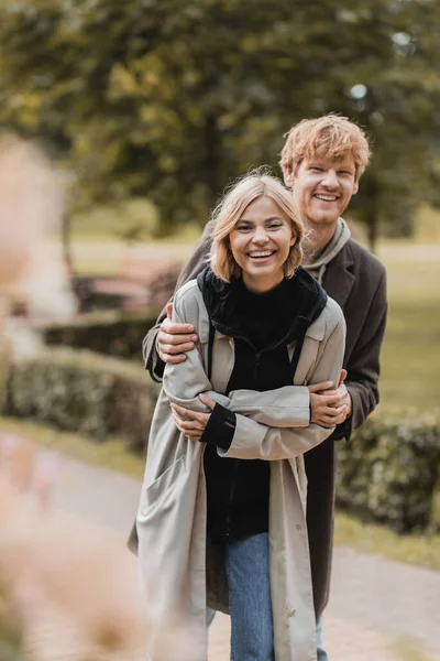 Alegre Ruiva Homem Abraçando Mulher Feliz Enquanto Sorrindo Juntos Durante — Fotografia de Stock