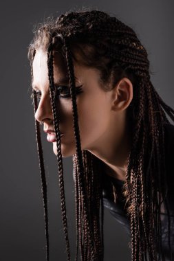 portrait of young woman with stylish makeup and dreadlocks isolated on grey clipart
