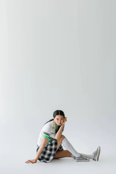 Moda Modelo Asiático Cardigan Cortado Olhando Para Câmera Enquanto Sentado — Fotografia de Stock
