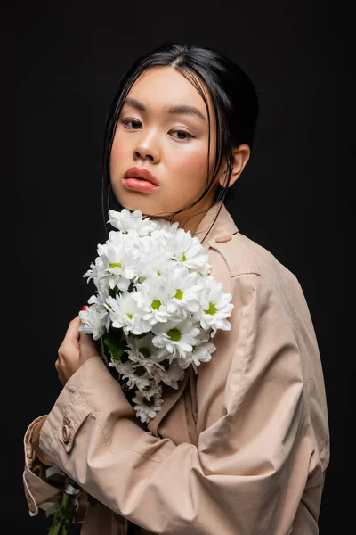 Snygg Asiatisk Kvinna Trenchcoat Håller Vita Krysantemum Isolerade Svart — Stockfoto