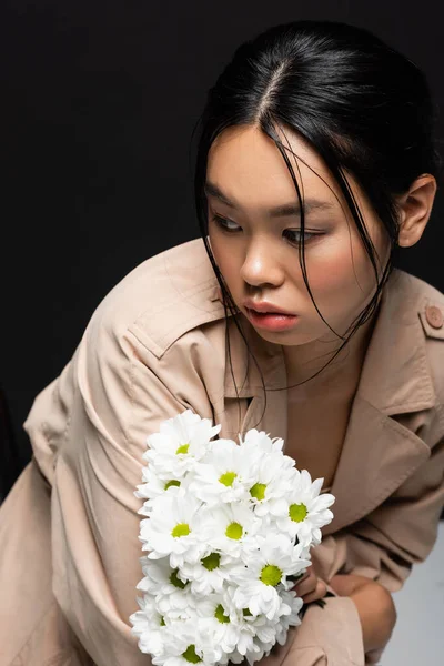 Trendy Azjatyckie Kobieta Płaszcz Trench Gospodarstwa Białe Kwiaty Patrząc Daleko — Zdjęcie stockowe