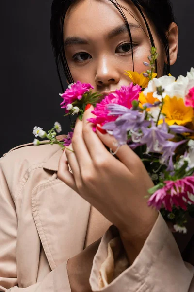 Elegante Modelo Asiático Gabardina Beige Sosteniendo Flores Borrosas Aisladas Negro — Foto de Stock