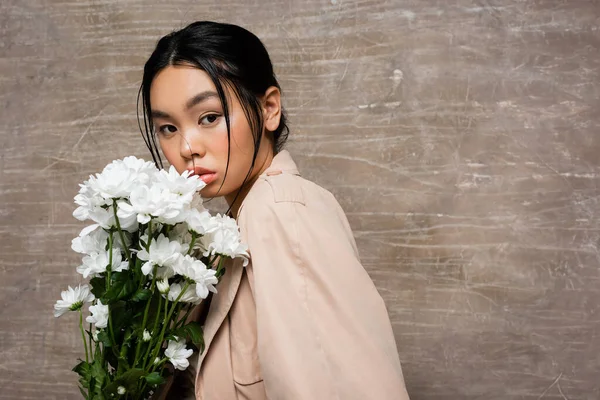 Stilvolle Asiatische Frau Trenchcoat Blickt Die Kamera Neben Beigen Chrysanthemen — Stockfoto