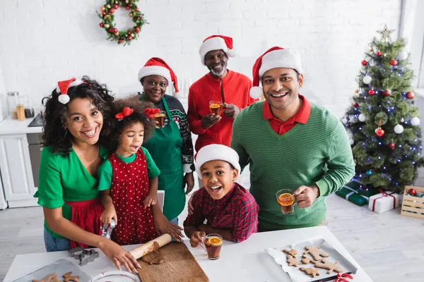 Mulheres africanas americanas lançando massa enquanto prepara biscoitos de Natal com a família — Fotografia de Stock