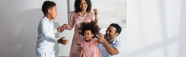 Fröhliche afrikanisch-amerikanische Familie Händchenhalten beim Spaß im Schlafzimmer, Banner — Stockfoto