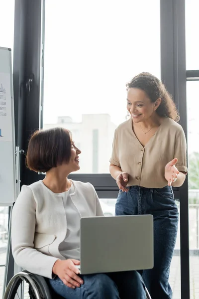 Smiling african american businesswoman talking to colleague with disability in office — Stock Photo