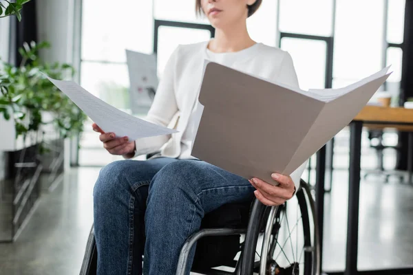 Cropped view of businesswoman in wheelchair working with documents in office — Stock Photo