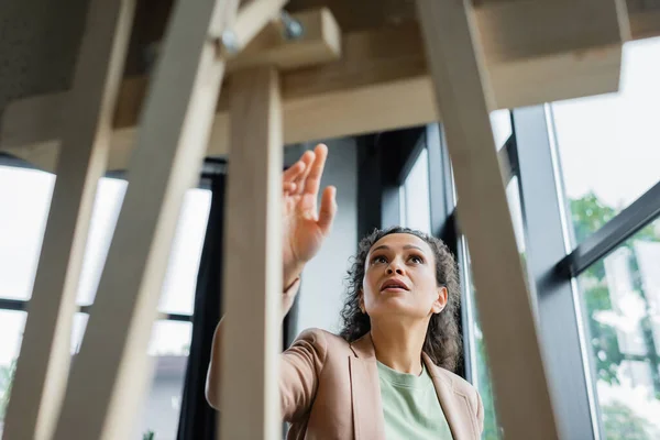 Afro-américaine femme d'affaires pointant avec la main au tableau flou dans le bureau — Photo de stock