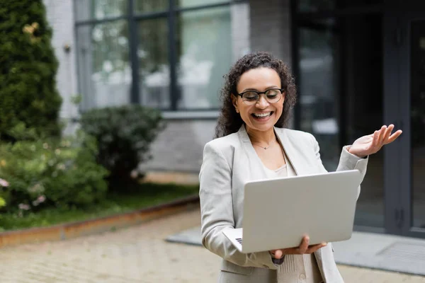 Smiling african american businesswoman gesturing during video call on laptop outdoors — Stock Photo