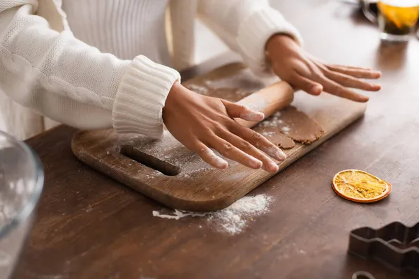 Vue recadrée de la femme afro-américaine roulant pâte près de coupe-biscuits dans la cuisine — Photo de stock