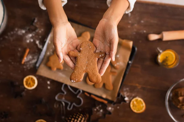 Ausgeschnittene Ansicht einer Afroamerikanerin mit Weihnachtsplätzchen in der Nähe eines verschwommenen Tabletts in der Küche — Stockfoto