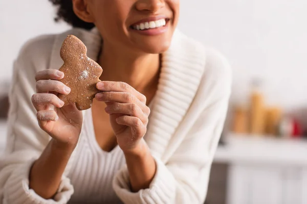 Ausgeschnittene Ansicht einer afrikanisch-amerikanischen Frau mit Mehl auf Händen, die Weihnachtsplätzchen hält — Stockfoto